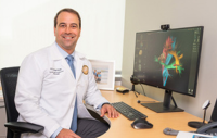 A neurosurgeon next to a tractography image